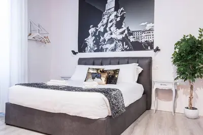a bedroom with a large bed with a black and white picture at Cozy Studio Campo dè Fiori in Rome