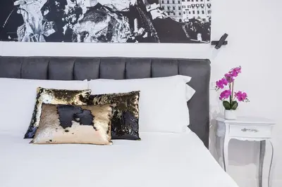 a bedroom with a white bed with a black and white wall at Cozy Studio Campo dè Fiori in Rome