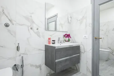a white bathroom with a sink and a mirror at Cozy Studio Campo dè Fiori in Rome
