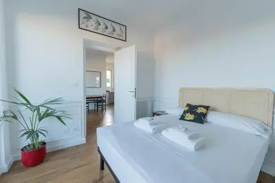 a white bed in a room with a potted plant at Aventino Terrace in Rome