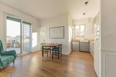 a kitchen and dining room with a table and chairs at Aventino Terrace in Rome