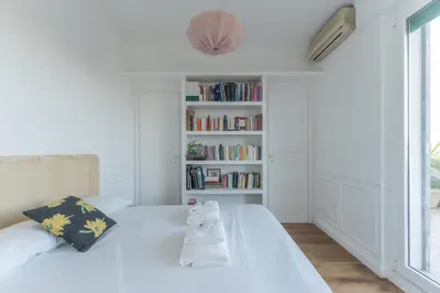 a white room with a bed and a book shelf at Aventino Terrace in Rome