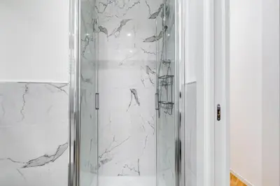 a bathroom with a shower with white marble walls at Apt in the heart of the city in Rome