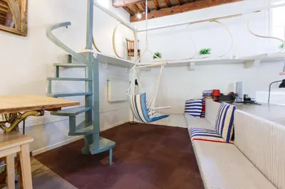 a spiral staircase in a room with a couch and a table at Pantheon Loft - B in Rome