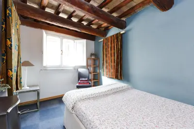 a bedroom with blue walls and a bed and a window at Pantheon Loft - B in Rome