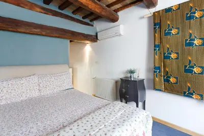 a bedroom with a bed and a wall with blue at Pantheon Loft - B in Rome