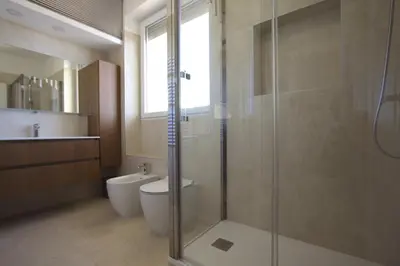 a bathroom with a toilet and a glass shower at Sunny Flaminio Terrace Penthouse in Rome