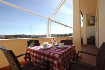 a table with a red and white table cloth on a balcony at Sunny Flaminio Terrace Penthouse in Rome