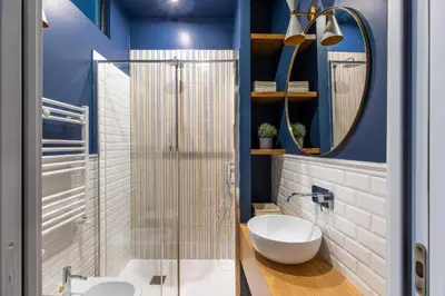 a bathroom with blue walls and a toilet and a mirror at iFlat The Monti Experience in Rome