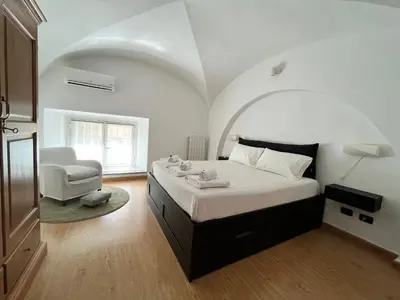 a bedroom with a large bed and a chair at Life is Roma Termini in Rome