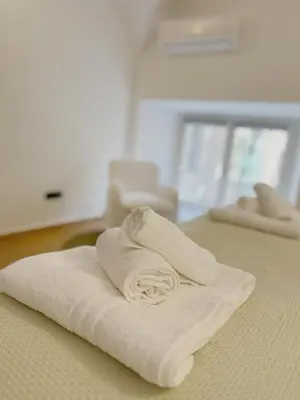 a pile of towels sitting on top of a bed at Life is Roma Termini in Rome