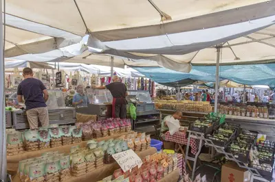 a market with people standing in front of a store at Farnese House in Rome