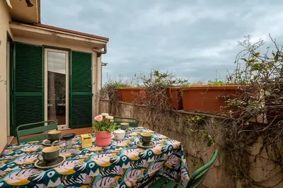a table with flowers on it on a patio at Tiffany's apartment Flaminio in Rome