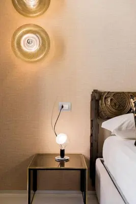 a table with a lamp on it next to a bed at My Trastevere Suite in Rome