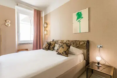 a bedroom with a large white bed with a window at My Trastevere Suite in Rome