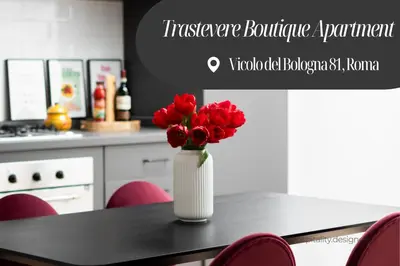 a vase with red flowers on a table in a kitchen at Trastevere Boutique Apartment in Rome
