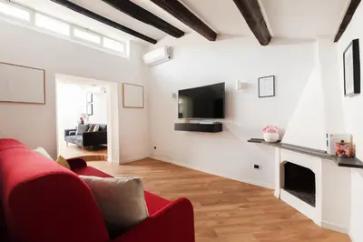 a living room with a red couch and a fireplace at Trastevere Boutique Apartment in Rome