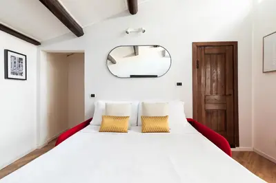 a bedroom with a large white bed with two pillows at Trastevere Boutique Apartment in Rome