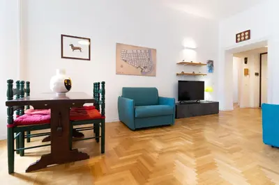 a living room with a table and a blue chair at Scipioni Holiday House in Rome