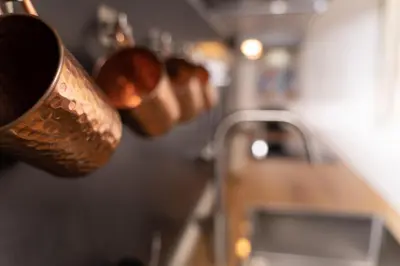 a kitchen with copper pots hanging from a wall at Scipioni Holiday House in Rome