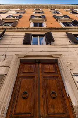 a tall building with a wooden door and windows at Scipioni Holiday House in Rome