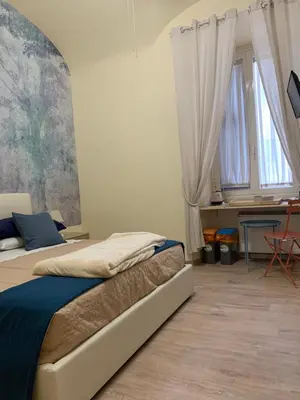 a bedroom with a bed and a desk and windows at Guest House VATICAN MUSEUMS PARVA DOMUS in Rome