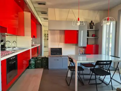 a kitchen with red cabinets and a table and chairs at Attico Cavour Prati, vicino Piazza Navona, Castel Sant'Angelo e San Pietro in Rome
