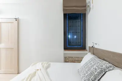 a white bedroom with a bed and a window at iFlat Cozy in Monti in Rome