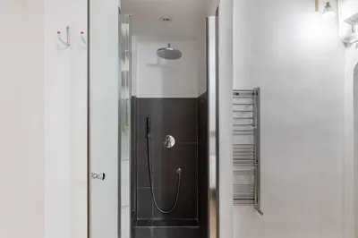 a shower in a bathroom with a black and white at iFlat Cozy in Monti in Rome