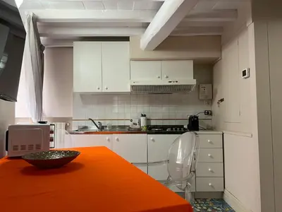 a kitchen with an orange table with a bowl on it at Artemide Domus Romae in Rome