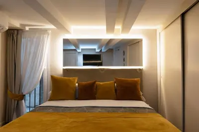 a bedroom with a bed with yellow pillows and a window at Artemide Domus Romae in Rome