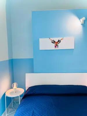 a blue bedroom with a bed with a butterfly picture on the wall at Dielle Apartments ROMA in Rome