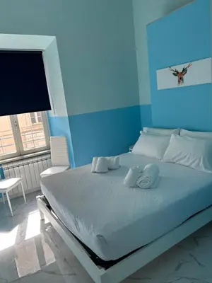 a bed in a room with a blue wall at Dielle Apartments ROMA in Rome
