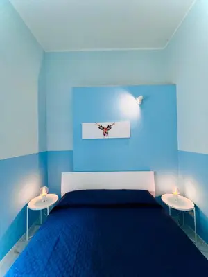 a blue bedroom with a bed and two tables at Dielle Apartments ROMA in Rome