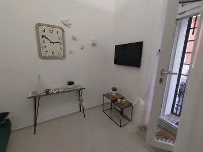 a living room with a clock on the wall and a table at A CASA DEI ROMANI in Rome