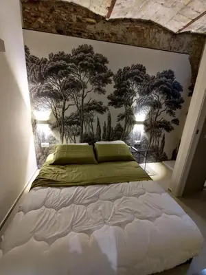 a bedroom with a large bed with trees on the wall at A CASA DEI ROMANI in Rome