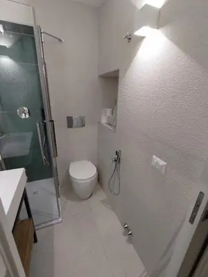 a bathroom with a toilet and a glass shower stall at A CASA DEI ROMANI in Rome