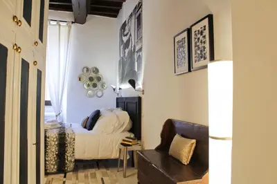 a small bedroom with a bed and a chair at Sophisticated Studio Decor in Rome