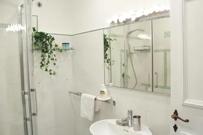 a white bathroom with a sink and a shower at Sophisticated Studio Decor in Rome