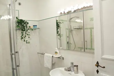 a white bathroom with a sink and a shower at Sophisticated Studio Decor in Rome