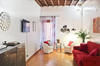 a living room with a red couch and chairs at Blue Navona Two Bedroom Apartment in Rome