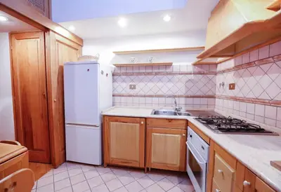 a kitchen with a white refrigerator and a sink at Blue Navona Two Bedroom Apartment in Rome