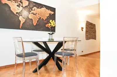 a dining room table with chairs and a map on the wall at Blue Navona Two Bedroom Apartment in Rome