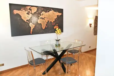 a glass table with chairs and a map on the wall at Blue Navona Two Bedroom Apartment in Rome