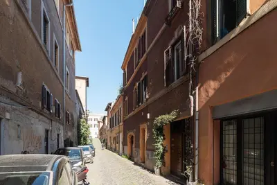 an alley with buildings and cars parked on a street at Trastevere Escape - Charme Holidays in Rome