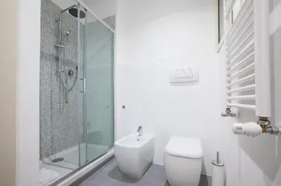 a bathroom with a shower and a toilet and a sink at My Trastevere Three Bedroom View Apartment in Rome