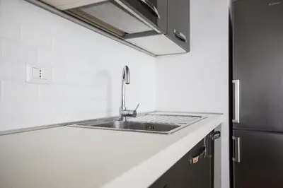 a kitchen with a sink and a refrigerator at My Trastevere Three Bedroom View Apartment in Rome