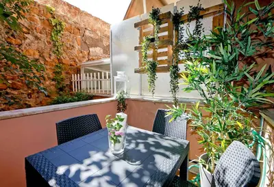 a table and chairs on a balcony with plants at Charming Patio Apartment Trastevere in Rome