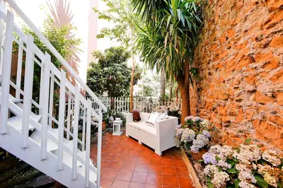 a white chair sitting next to a brick wall at Charming Patio Apartment Trastevere in Rome
