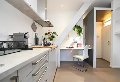 a kitchen with white counters and a white chair at Terrace Modern Studio Trastevere in Rome
